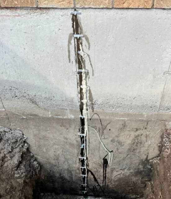 Fissures dans une dalle de béton, signe visible d'un problème structurel lié à l'humidité